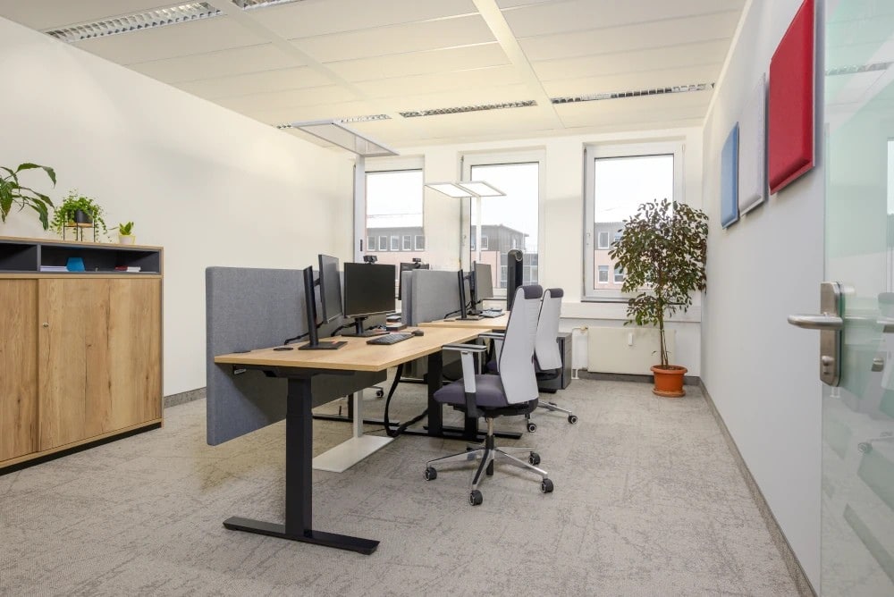 Modernes Büro mit höhenverstellbaren Schreibtischen und großen Fensterflächen im Brockhaus Zentrum Leipzig